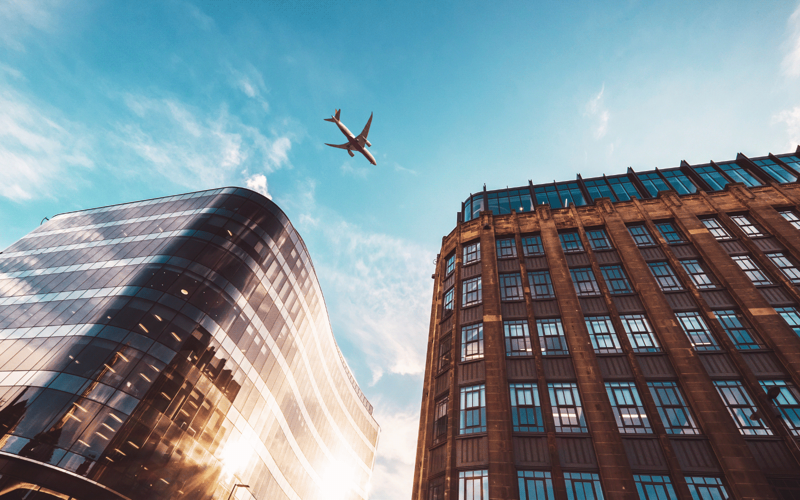 Plane flying over Glasgow city centre looking from ground level